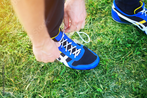 Man laces shoelaces in running shoes