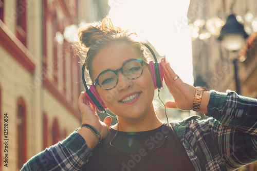 Beautiful woman posing on the street with headphones.

