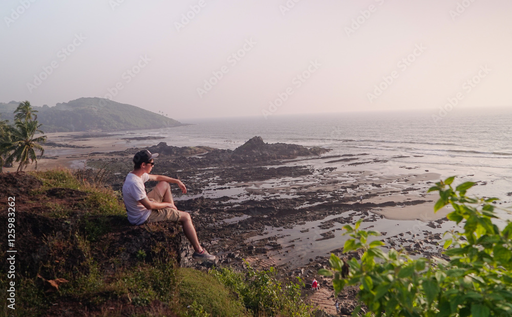 Young traveler looks at the beautiful landscape with the sea