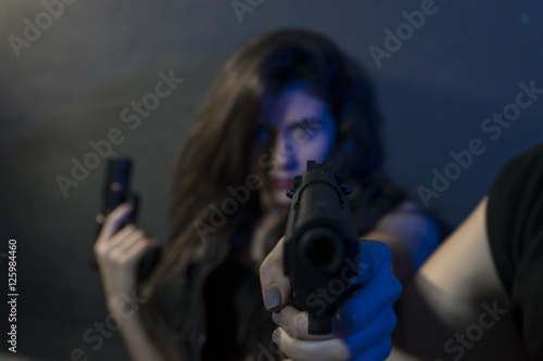 Shot, beautiful and dangerous girl with gun and machine gun in s photo