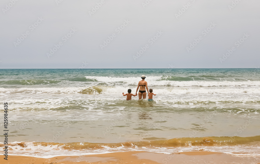 Woman with two children goes to sea. South Western Sicilian Coast