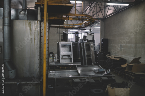 Metallurgy industry interiors. Details from factory for production of heavy pellet stoves and boilers. Sector for painting. Extremely dark conditions and visible noise.