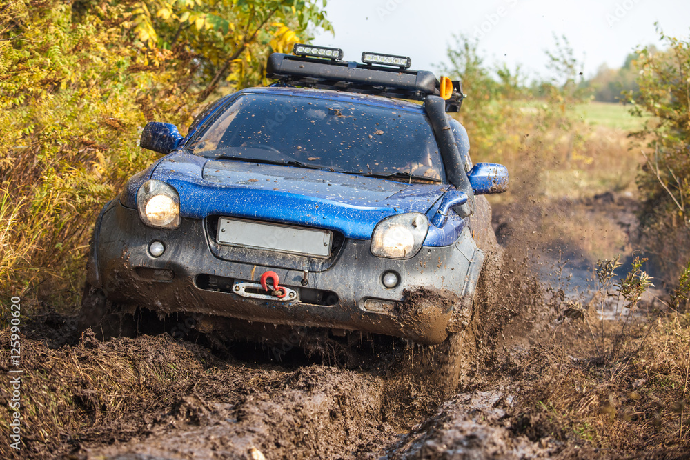 Japanese off-road car moving through deep mud