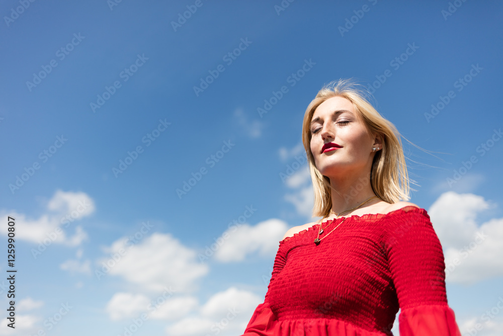 Frau mit rotem Kleid vor blauem Himmel Frau mit rotem Kleid vor blauem Himmel
