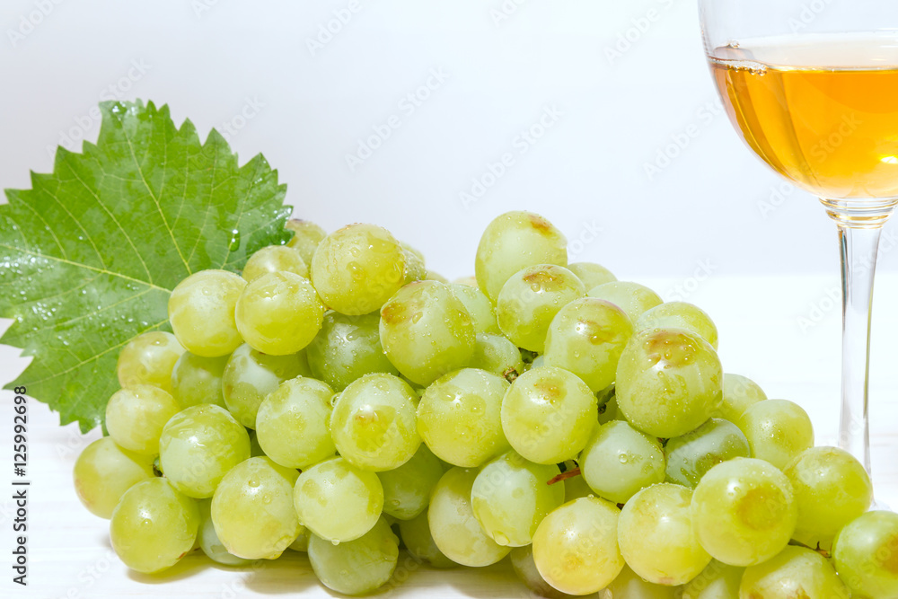 Bunch of ripe muscat grapes and wine glasses with white wine Bunch of ripe muscat grapes and wine glasses with white wine