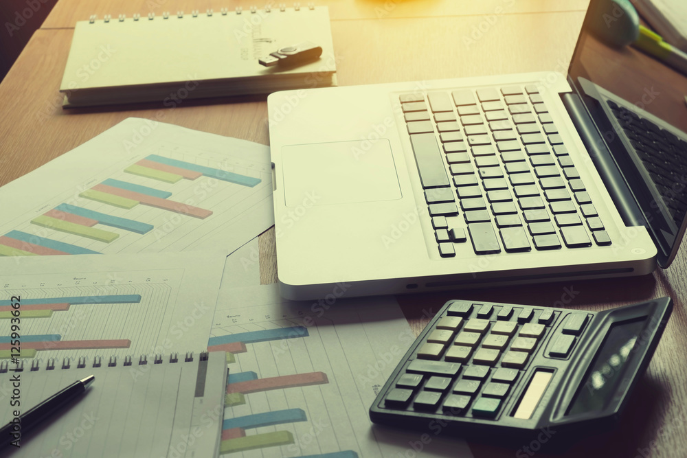 Laptop, calculator with financial documents on wooden table Laptop, calculator with financial documents on wooden table