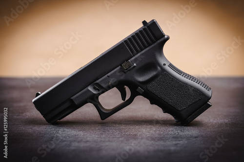 black 9mm pistol on a black wooden table