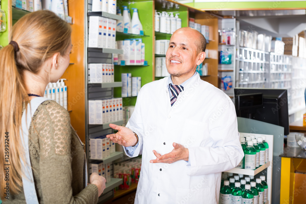 Pharmacist and client in pharmacy .