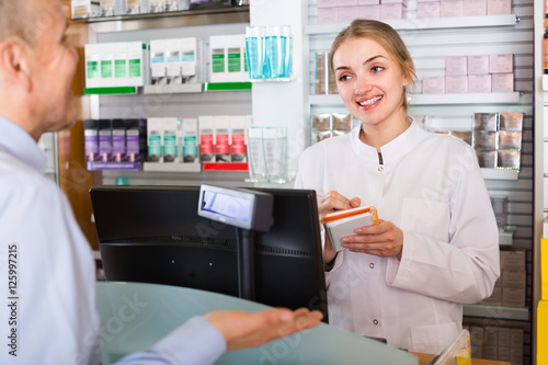 Pharmacist serving client in pharmacy .