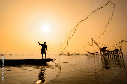 A man catching fish by used fishnet with square dip net background at Pakpra village, Phatthalung, Thailand