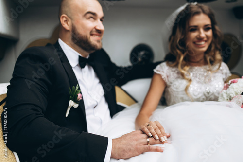 Fototapeta Naklejka Na Ścianę i Meble -  Stylish bride and bearded muscular groom posing on the wedding