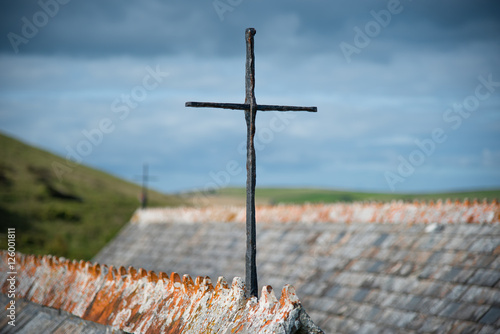 Iron cross on the roof gable of St Enodoc Curch near Daymer bay in north Cornwall. photo