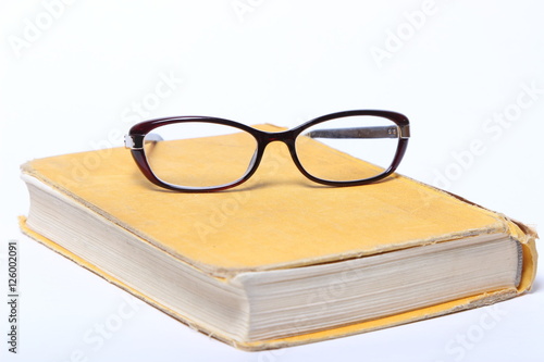 spectacles lying on old book