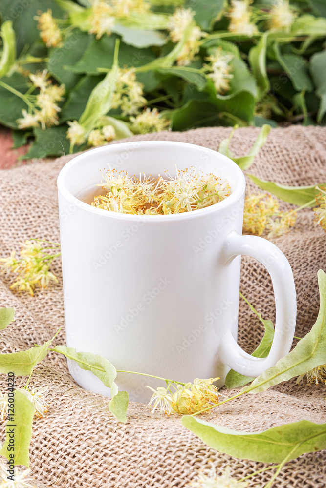 Linden tea in a cup on a wooden background. Linden tea in a cup on a wooden background.