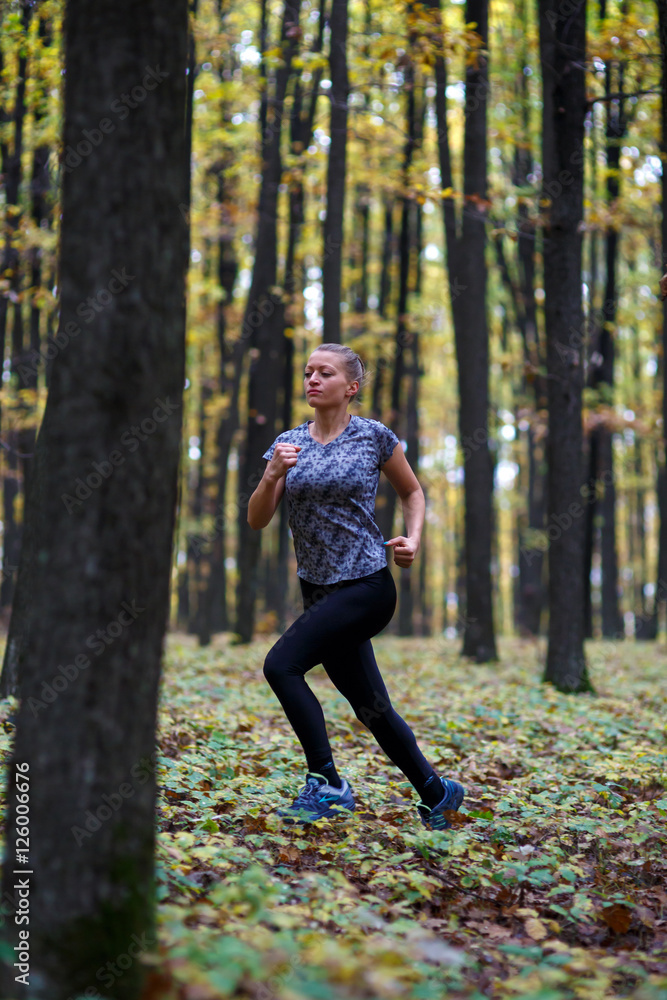 Young woman trail running in the forest