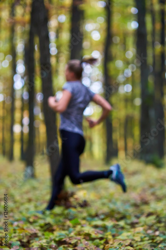 Young woman trail running in the forest