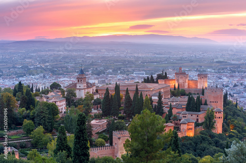 Palace and fortress complex Alhambra with Iglesia de Santa Maria, Palacios Nazaries and Alcazaba during sunset in Granada, Andalusia, Spain © Kavalenkava