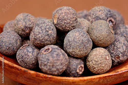 Allspice in a wooden spoon photo