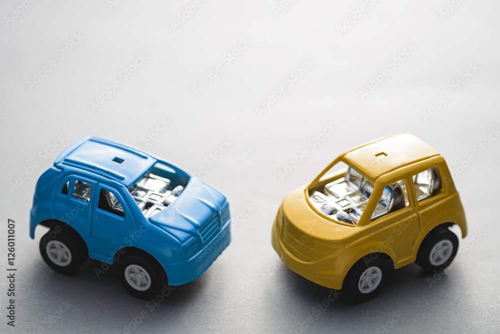 Two small toy car standing on gray background Two small toy car standing on gray background