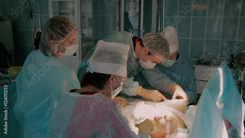 Team of surgeons in process of completing the reimplantation surgery photo