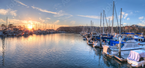 Photo Sunset over sailboats in Dana Point harbor in the fall.