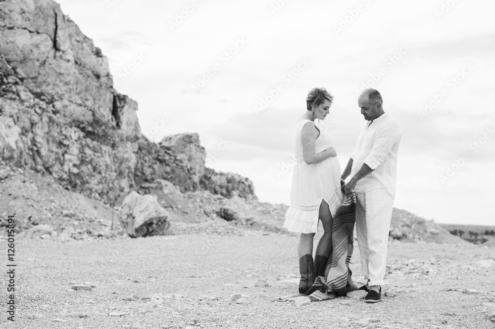 Pregnant woman and man photo shoot in a stone quarry