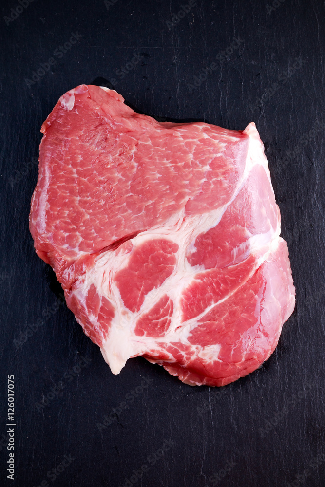 Top view raw pork rib eye steak on stone background Top view raw pork rib eye steak on stone background