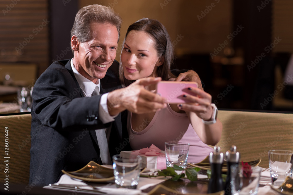 Cheerful couple taking a selfie in the restaurant Cheerful couple taking a selfie in the restaurant