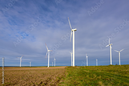 Wind turbines generating electricity surrounded by agricultural fields in Polish country side. Poland, Europe.