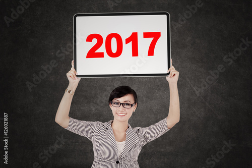 Pretty entrepreneur holding billboard with 2017 photo