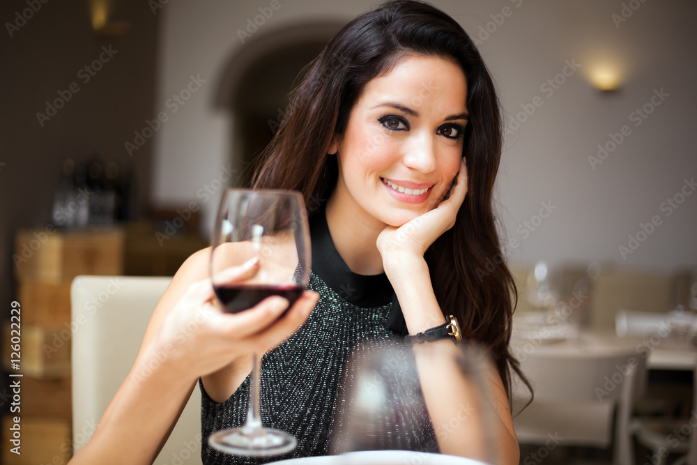Woman drinking red wine in a restaurant Woman drinking red wine in a restaurant
