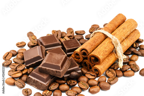 Dark chocolate bar, cubes, cinnamon sticks and coffee beans isolated on white background.