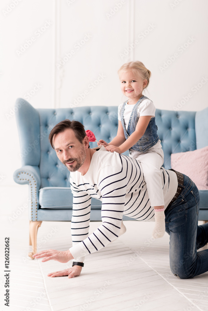 Fototapeta premium Happy pretty girl sitting on her fathers back