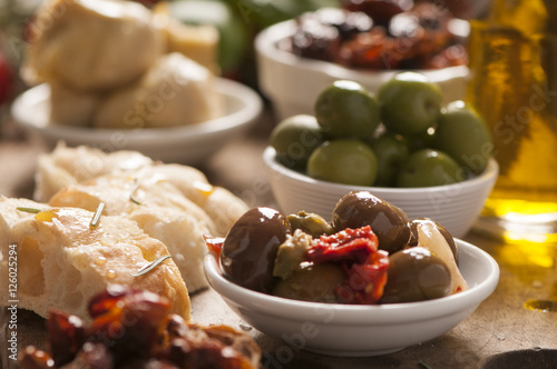 Bread, olives and artichokes served on a wooden table