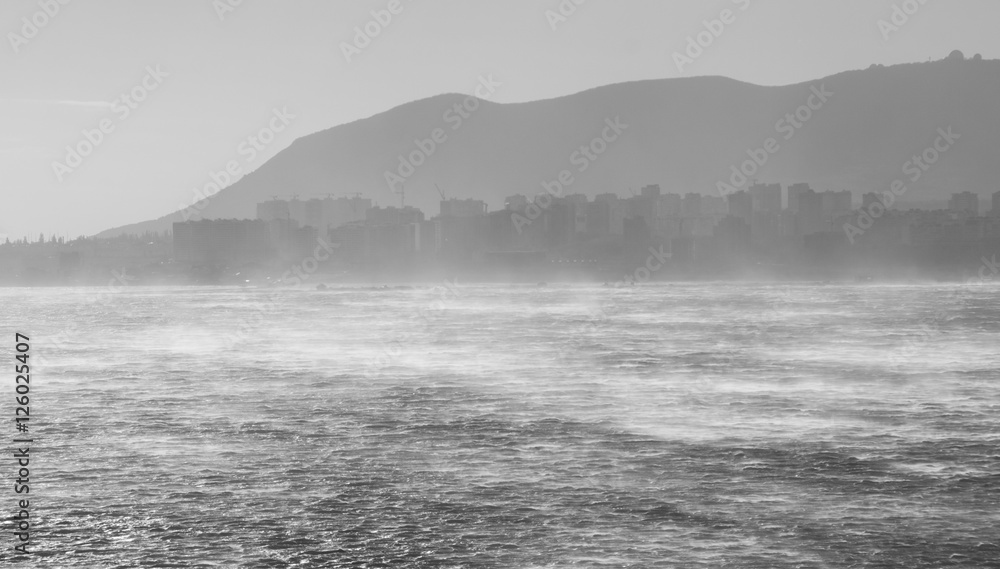 Sea on the background of the city in fog Sea on the background of the city in fog