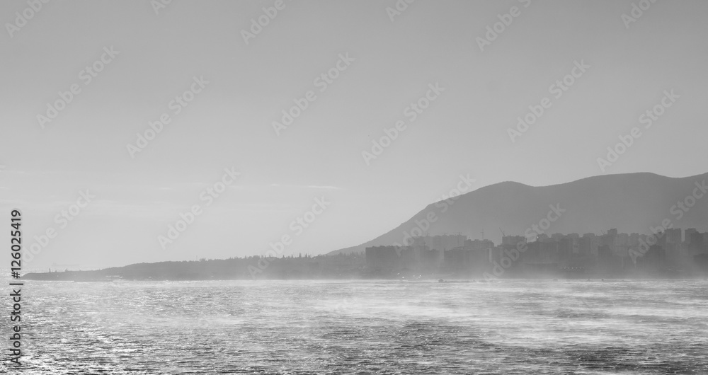 Sea on the background of the city in fog