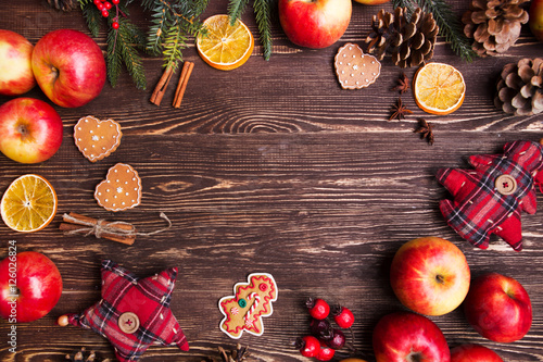 Christmas Holiday background with apples and decorations over wooden table