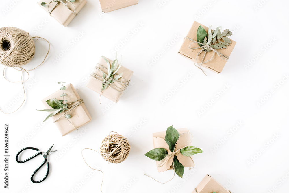 creative arrangement pattern of craft boxes and green branches on white background. flat lay, top view creative arrangement pattern of craft boxes and green branches on white background. flat lay, top view