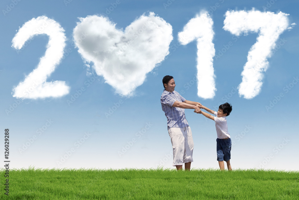 Happy father and boy with 2017 at field Happy father and boy with 2017 at field