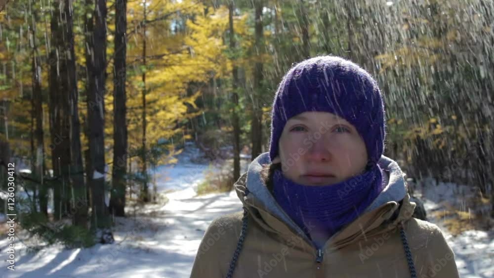 Snow falls from the trees onto the head of the girl in the winter forest Snow falls from the trees onto the head of the girl in the winter forest