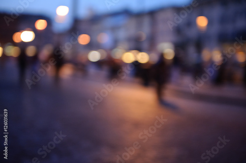 Defocused purple orange bokeh of tourists on Piazza Navona at ni