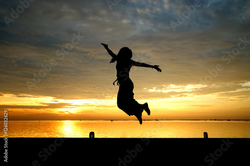 silhouette of woman jumping at the sea