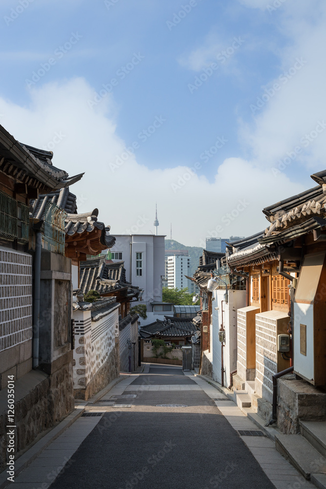 Naklejka premium Mała i pusta aleja oraz stare budynki w wiosce Bukchon Hanok w Seulu w Korei Południowej. Skopiuj miejsce.