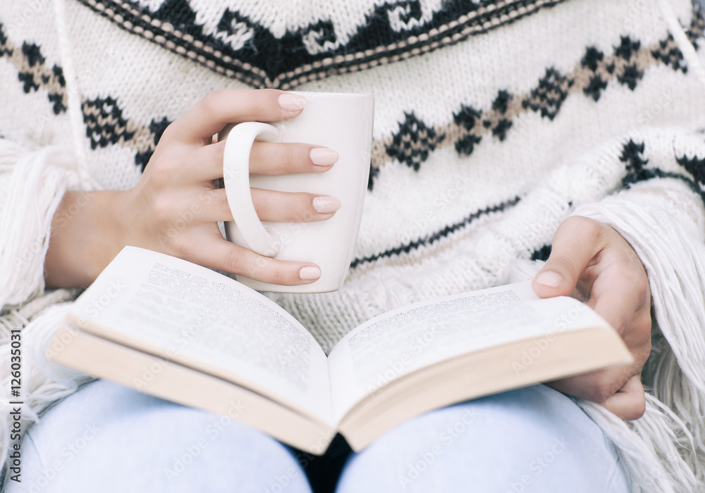 Φωτογραφία Close up of woman hands holding a book and a cup of coffee