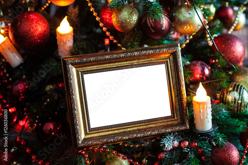 Empty blank photo frame in christmas decorated background with toys and candle lights