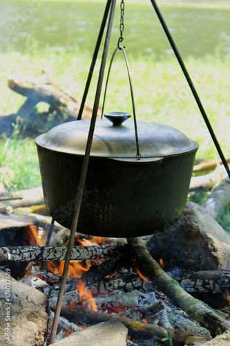 Cooking outdoors. Cauldron on a fire in the forest