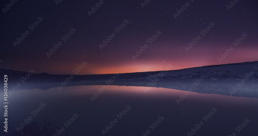 Morning dawn on a starry background sky reflected in the water o Morning dawn on a starry background sky reflected in the water o