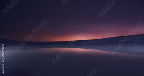 Morning dawn on a starry background sky reflected in the water o