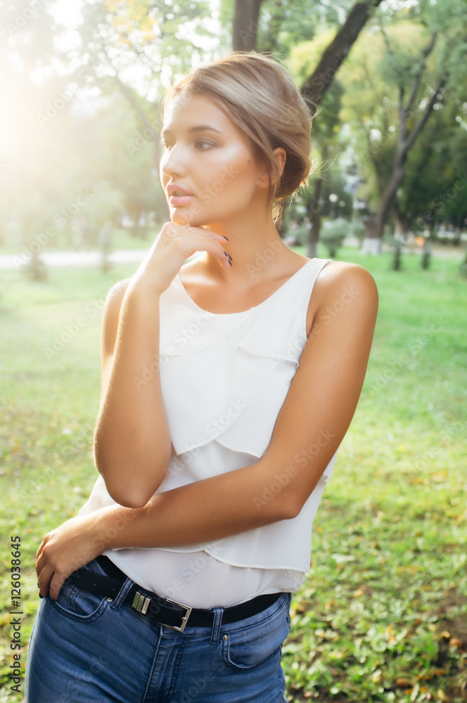 Bautiful girl wearing a white shirt poses in a city park Bautiful girl wearing a white shirt poses in a city park