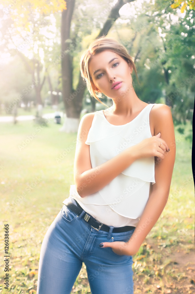 Bautiful girl wearing a white shirt poses in a city park Bautiful girl wearing a white shirt poses in a city park